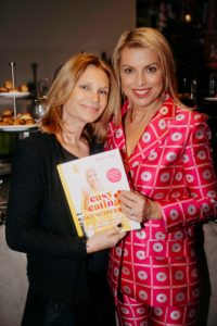 Zwei lächelnde Frauen stehen eng beieinander und halten gemeinsam das Buch „Easy Eating – Das Workbook“ in der Hand.