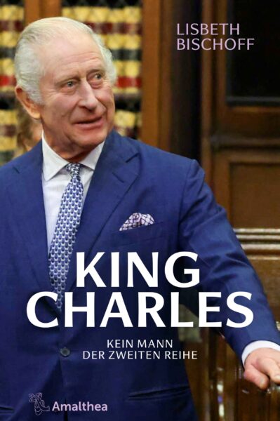 Buchcover mit einem älteren Mann mit grauen Haaren in einem blauen Anzug, stehend in einem holzgetäfelten Raum mit Bücherregalen. Der Titel lautet „King Charles – Kein Mann der zweiten Reihe“, darüber der Name „Lisbeth Bischoff“. Unten ist das Logo des Verlags Amalthea zu sehen.
